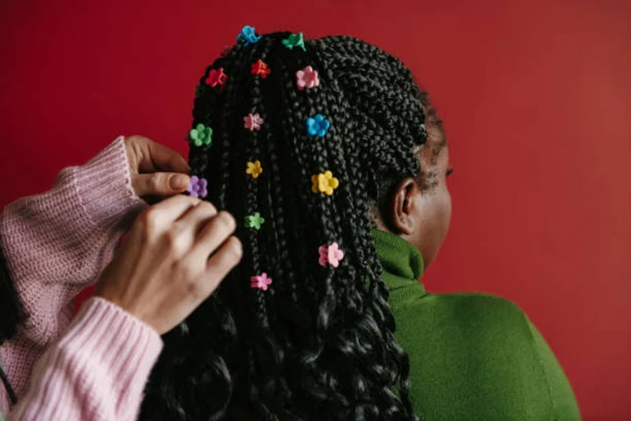 Hairdresser Putting on Colorful Clips on Braided Hair of African Woman