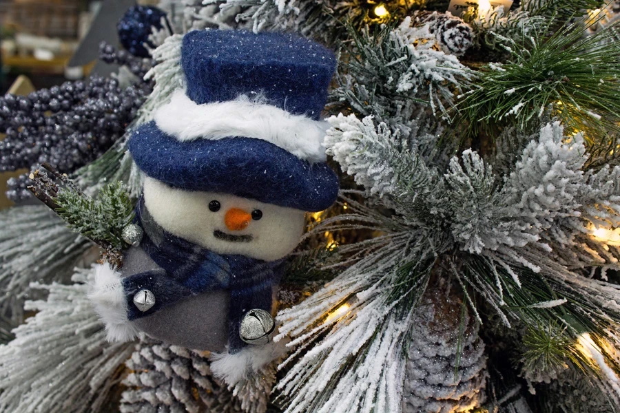 Handmade snowman ornament on a flocked Christmas tree