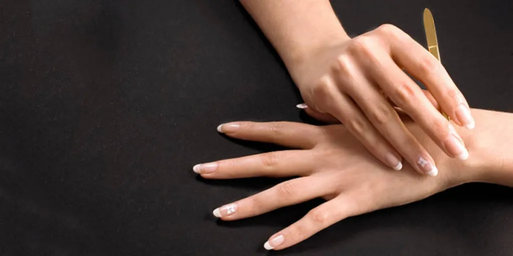 Hands with white French manicure with flower design