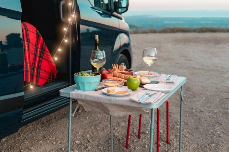 Healthy vegan picnic celebration in a camper van with landscape in the background