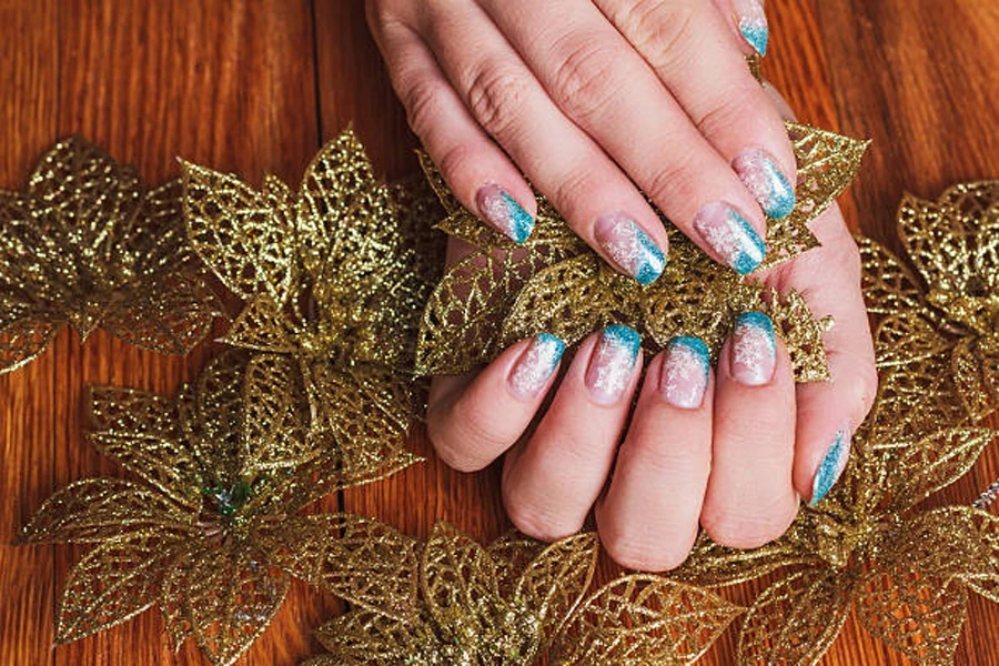 Light pink festive French nails with blue accent nail art