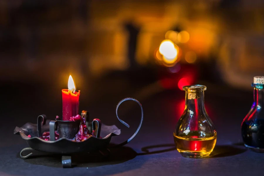 Lighted Candle on Holder Beside a Glass Jar