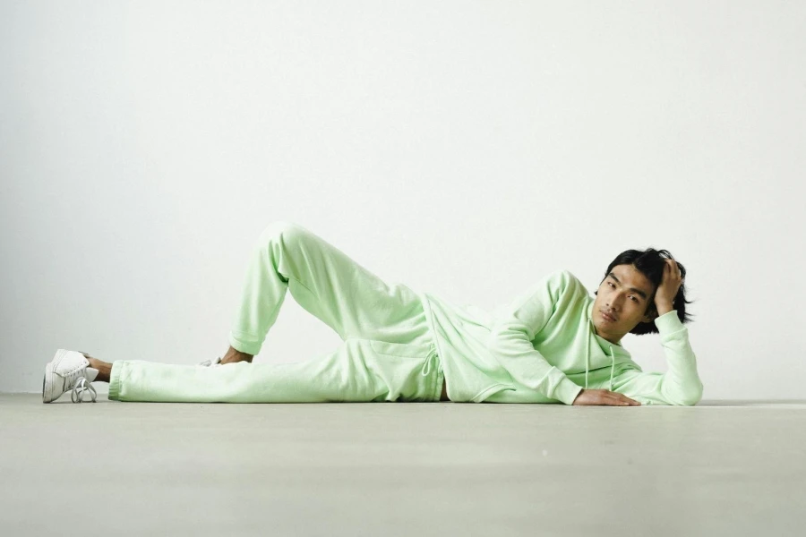 Man in Green Sweater Lying Down on the Ground