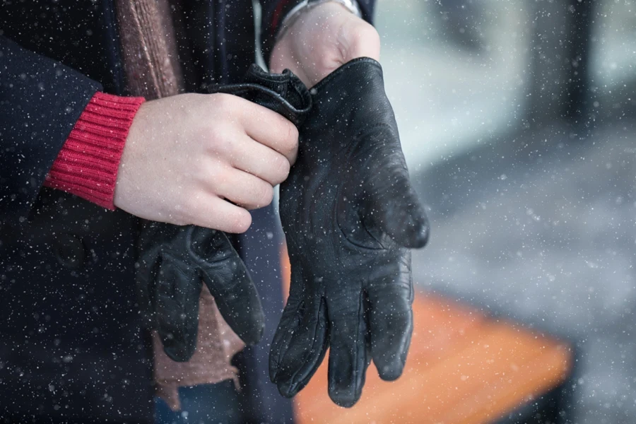 Man putting on insulated leather gloves