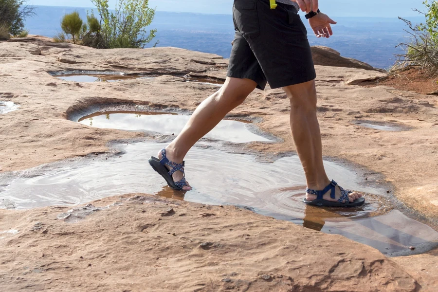 Man walking through water in walking sandals