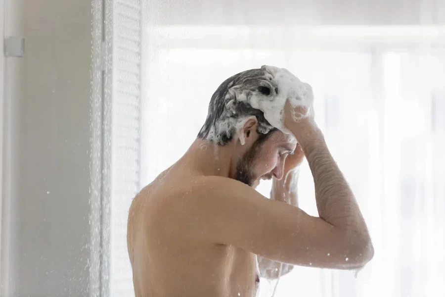 Naked young Caucasian man stand in bathroom