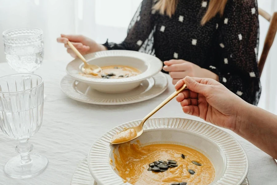 People using soup spoons on their dish