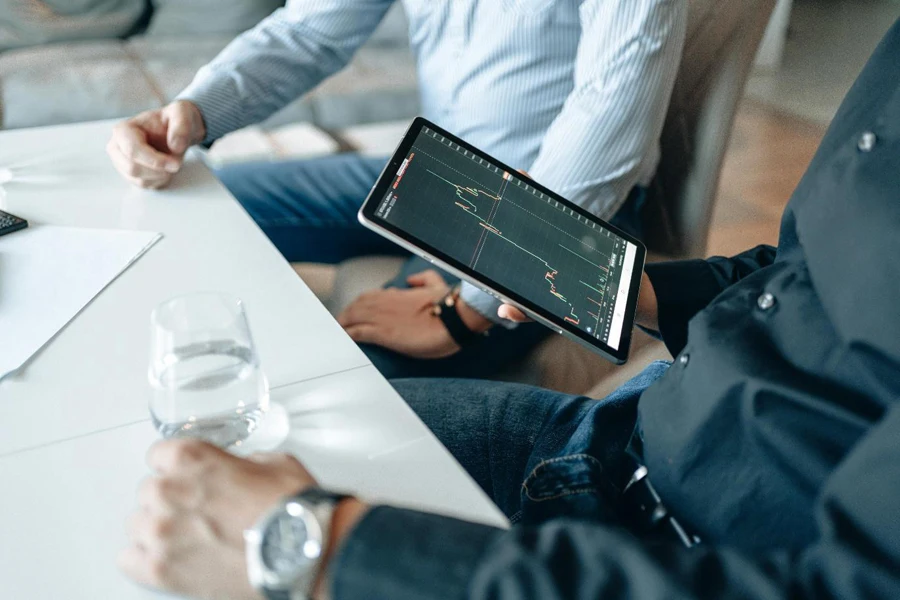 Person Holding a Black tablet with Graph on Screen