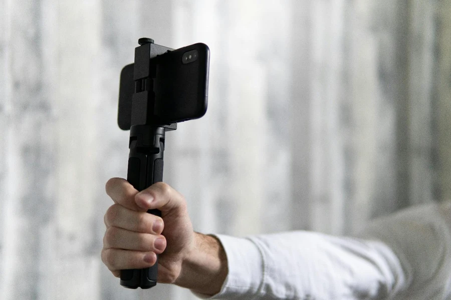 Person Holding a Smartphone on a Selfie Stick