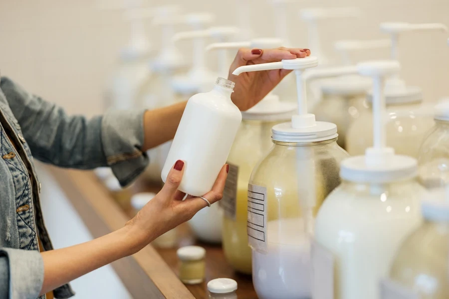 Person refilling container with lotion