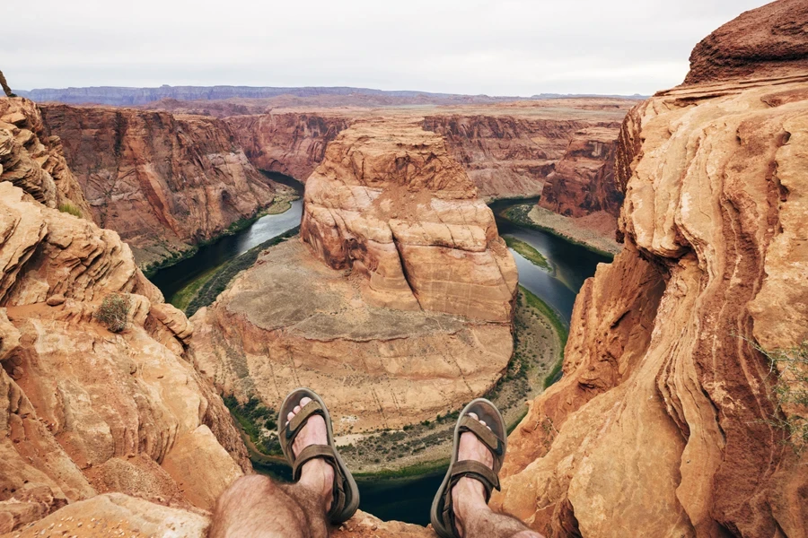 Person sitting in a canyon in walking sandals