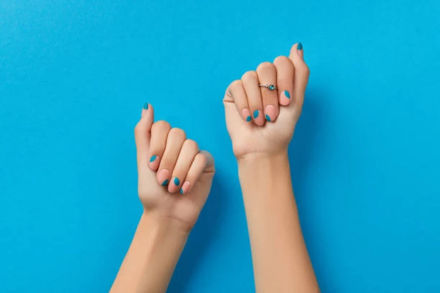 Person with pink nails topped with blue accent