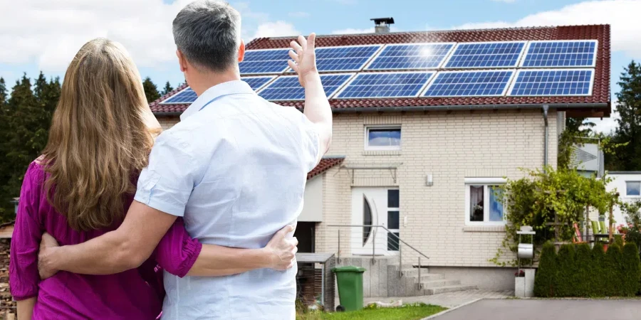 Rear View Of Couple Standing In Front Of Their House