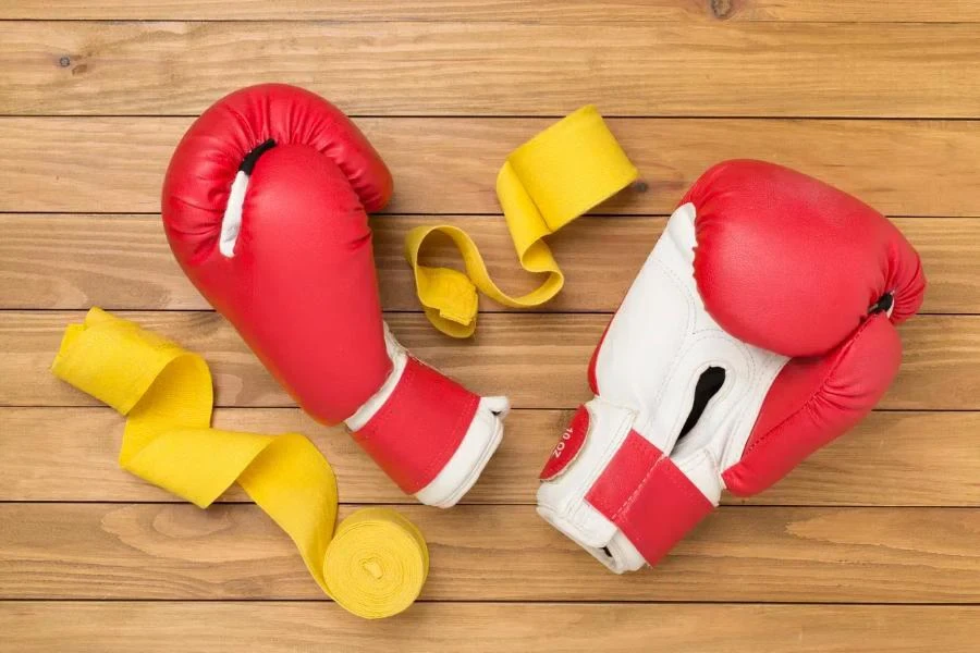 Red boxing gloves on wooden background