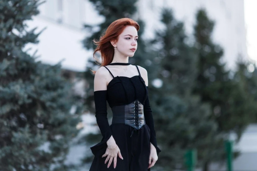 Redhead woman in black outfit standing