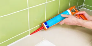 Sealing shower tiles with a caulk gun