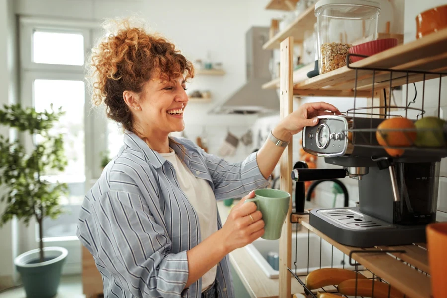 Smiling woman using a high-end coffee machine