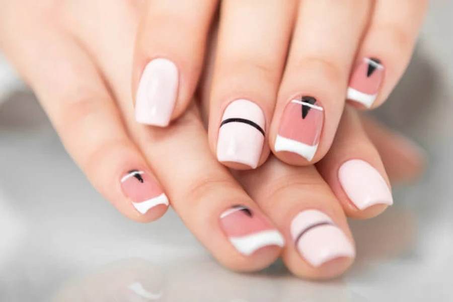 Soft pink nail polish with geometric patterns on top