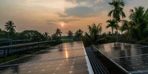 Sunset on some solar panels in a village which has fields in the distance