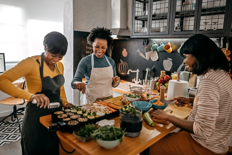 Three female friends cooking in the kitchen for Thanksgiving