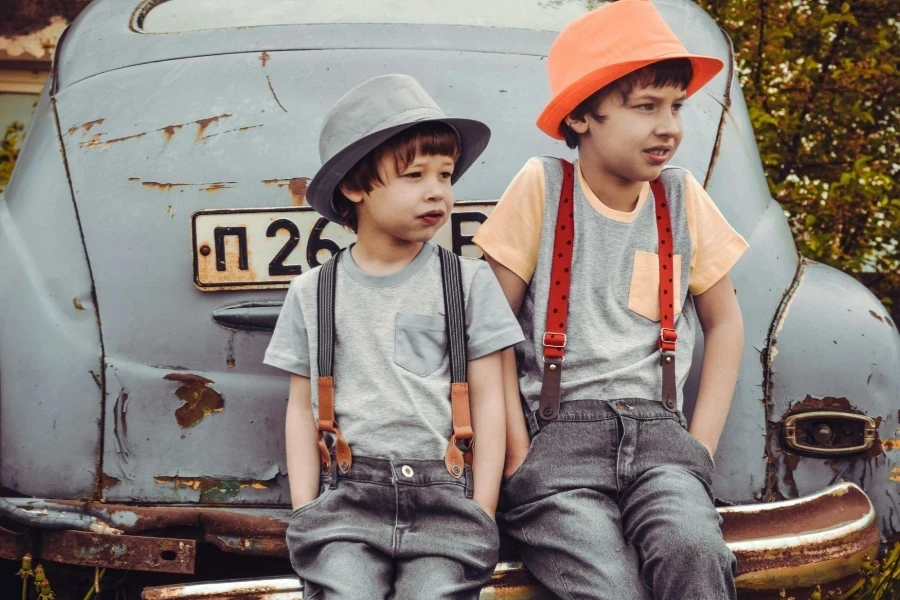 Two Boys Sitting on Vehicle Bumper