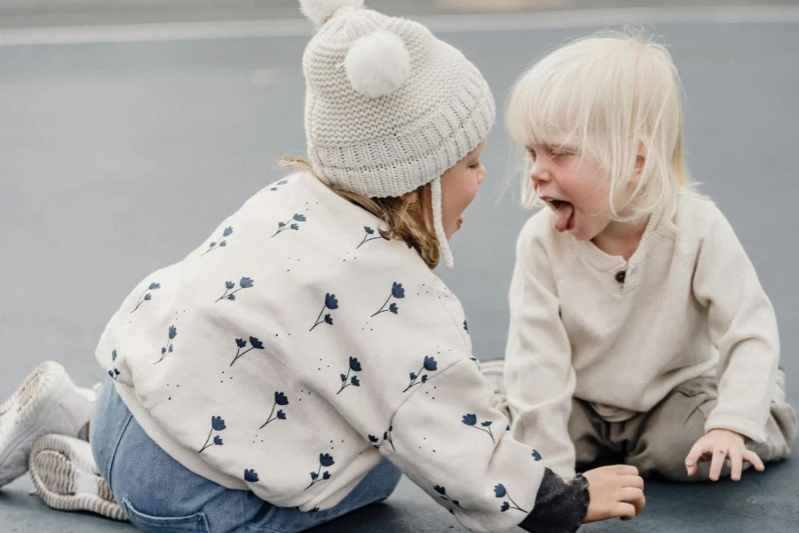 Two kids playing on gray cement floor