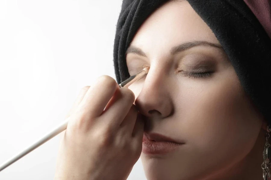 Woman Applying Cosmetics On Her Eyelid