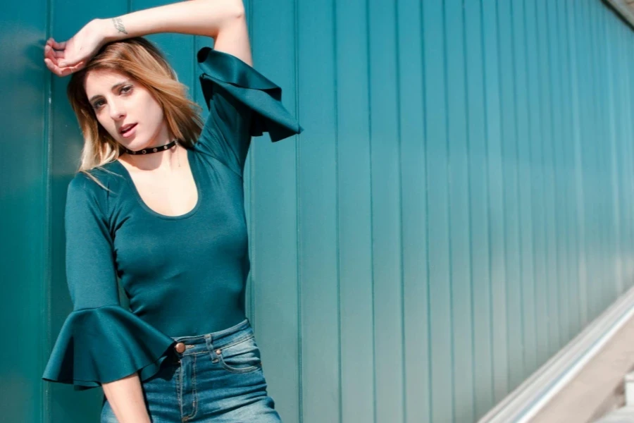 Woman Leaning Against Blue Wall