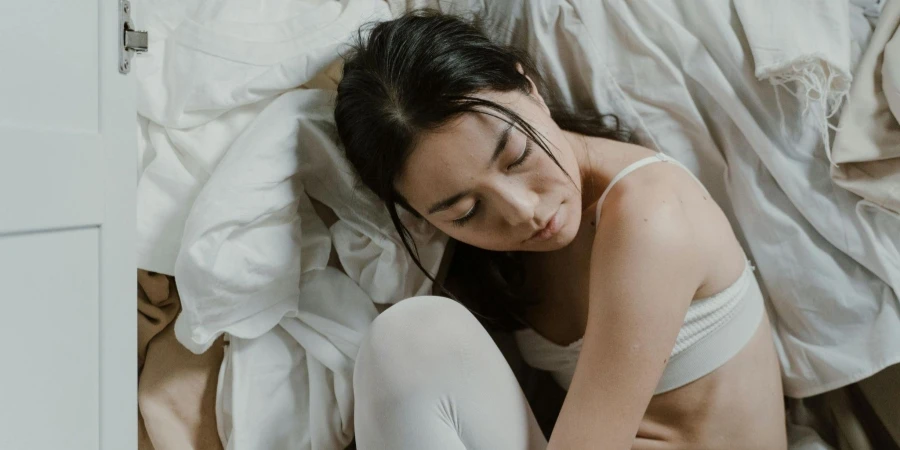 Woman Sitting beside a Pile of Clothes