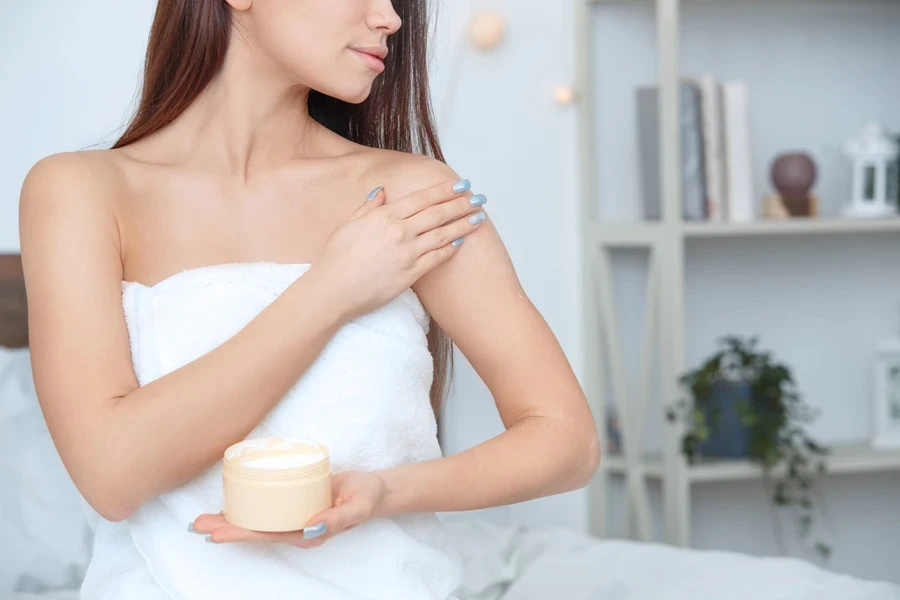 Woman applying skin cream before bed