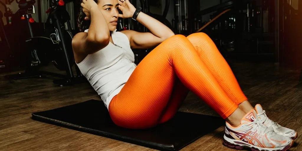 Woman doing situps in orange leggings