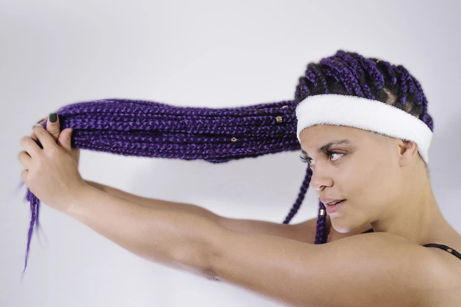 Woman holding long blue barrel twist locs