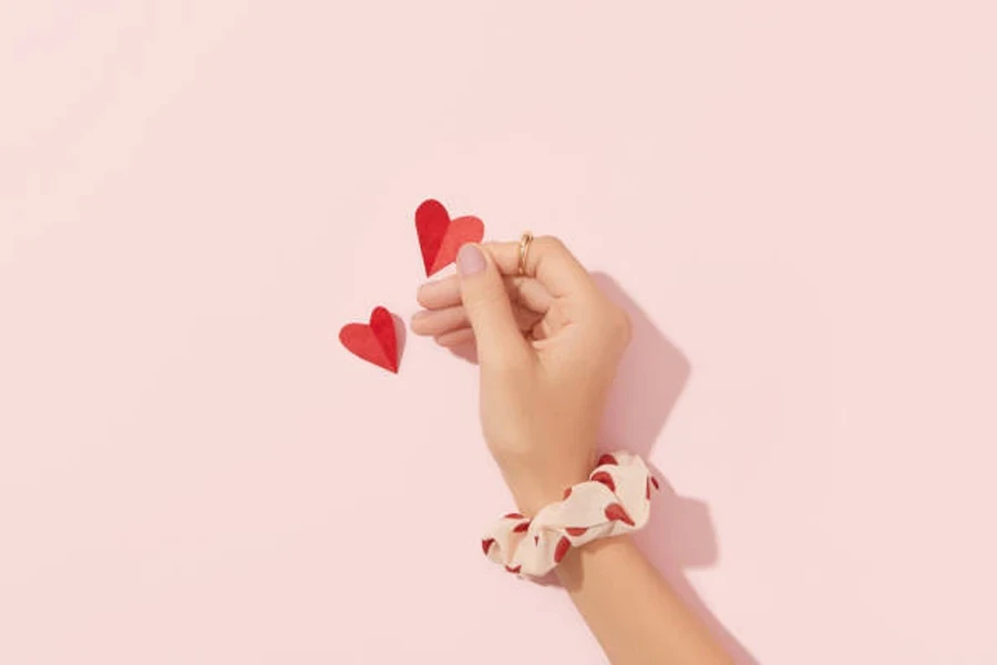 Woman holding paper heart with short nude nails in matte