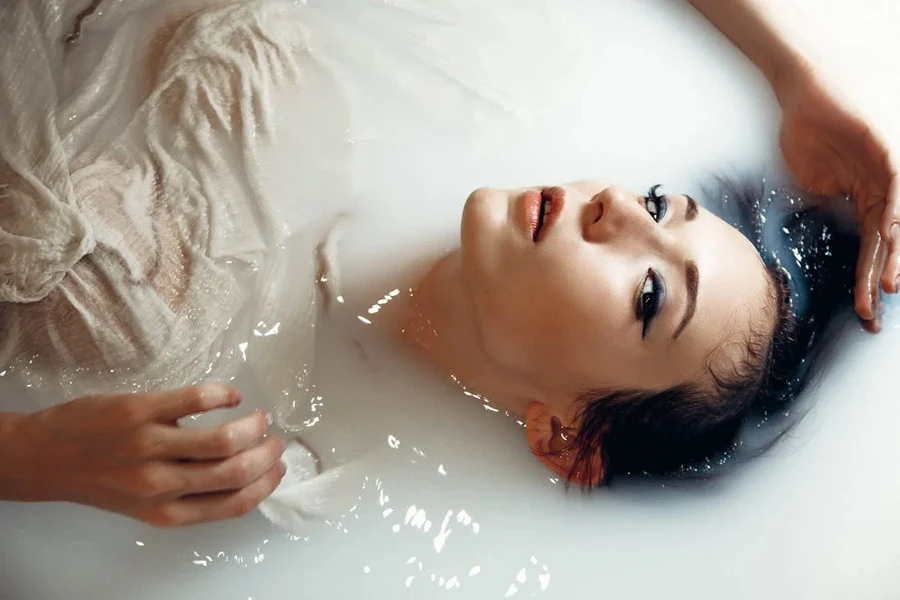 Woman in white shirt taking a milk bath