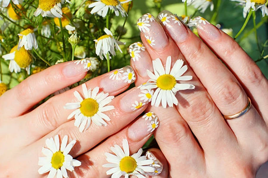 Woman wearing clear gel nails with nail art flowers