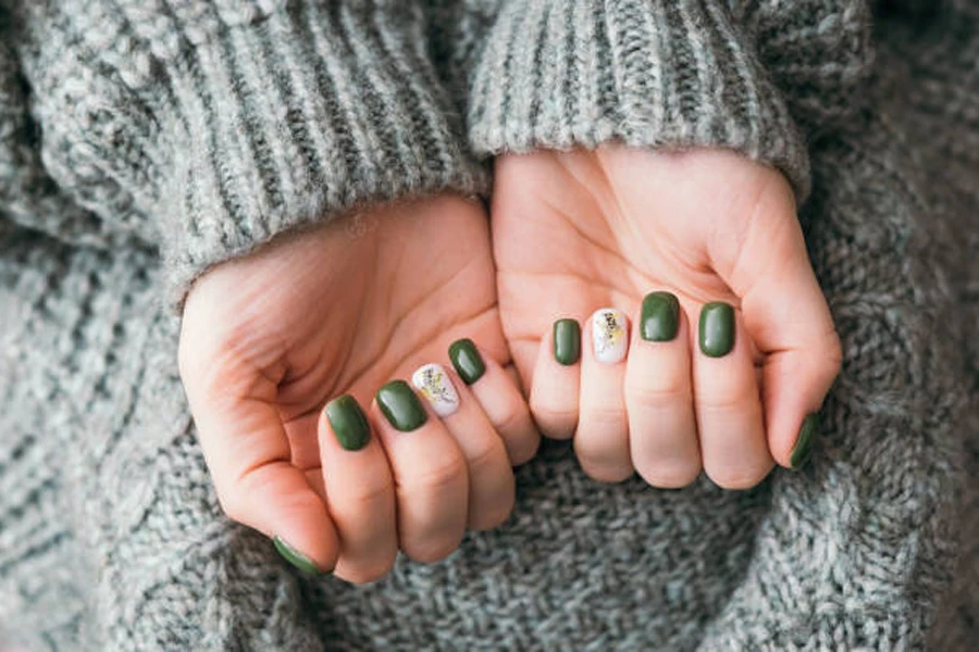 Woman wearing sweater with metallic olive green painted nails