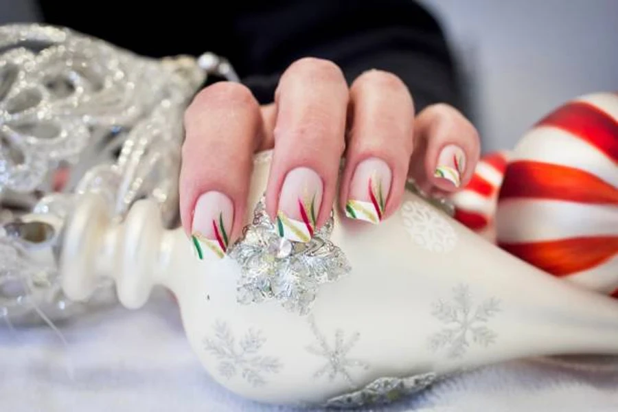 Woman with Christmas French nails holding tree ornament