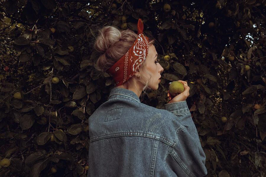 Woman with a bandana wrapped around a messy bun style