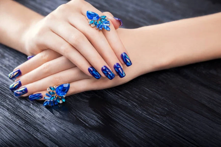 Woman with dark blue holographic nail design reflecting light