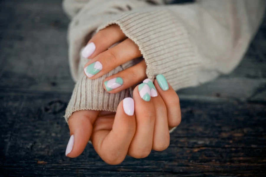 Woman with light pink and baby green artificial nails