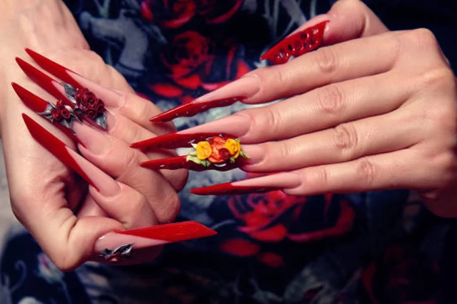 Woman with pointy red nails with 3D flowers on top