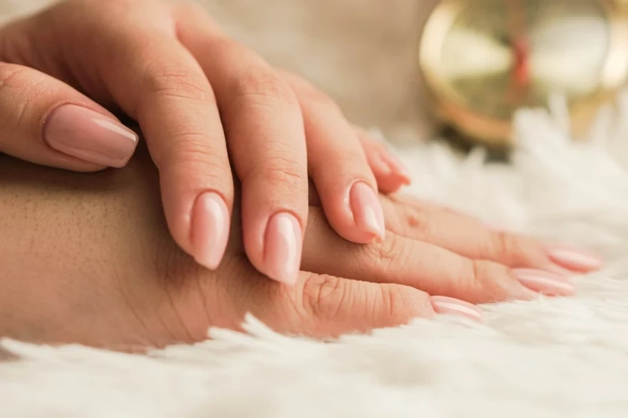 Woman’s hands with full set of neutral nude nails