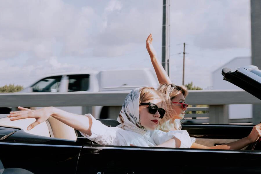 Women in a convertible car wearing headscarves