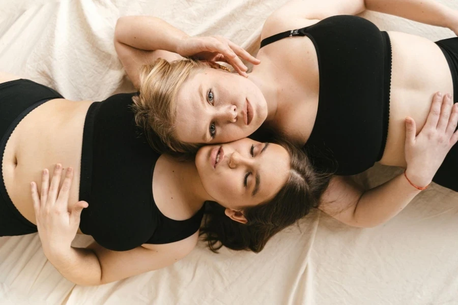 Women in black bralette lying down together