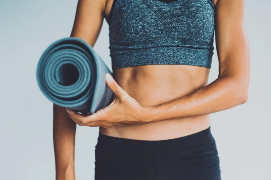 Young woman with yoga mat