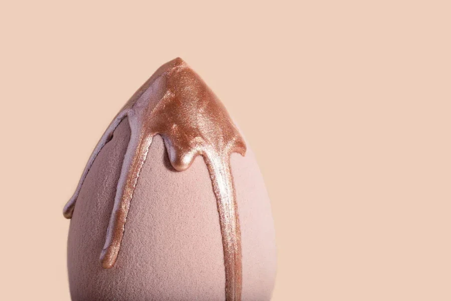 A beauty blender with dripping bronzer