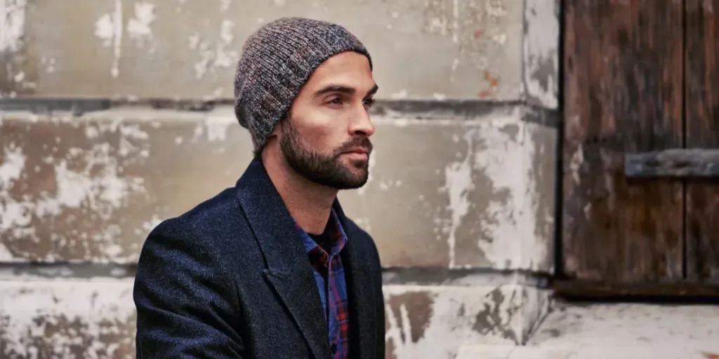 A handsome man wearing a fisherman beanie and coat