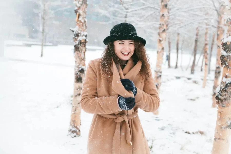 A happy model in a brown wrap coat during winter