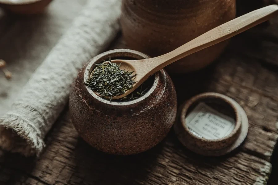 A tea leaf jar near a kitchen towel