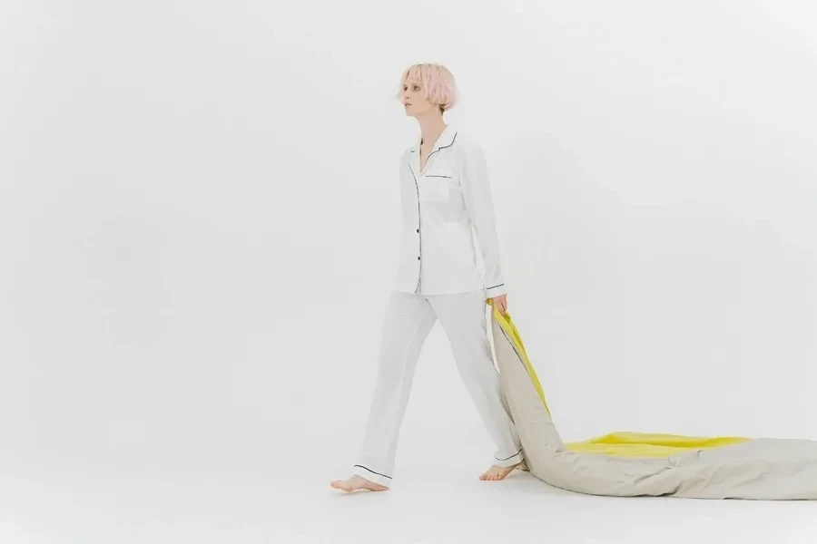 A woman in sleepwear dragging a quilt